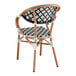 A Lancaster Table & Seating outdoor arm chair with a black and white rattan weave seat and back.