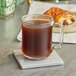 A glass mug of Nescafe Whole Bean Espresso on a coaster.