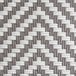 The woven white and gray rattan surface of a Lancaster Table & Seating outdoor side chair.