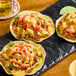 A plate of three tacos with meat and Chef-Mate Jalapeno Cheddar Cheese Sauce on top.