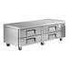 A stainless steel refrigerated chef base with four drawers and caster wheels.
