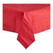 A red Table Mate tablecloth on a table with a folded napkin.