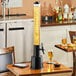 A black Choice beer tower on a wood table with food and drink.