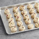 Preformed Otis Spunkmeyer red, white, and blue cookie dough on a gray baking sheet.