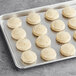 Preformed Otis Spunkmeyer sugar cookies on a baking sheet.