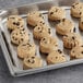 Preformed Otis Spunkmeyer chocolate chip cookies on a baking sheet.