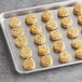 Preformed Otis Spunkmeyer peanut butter cookies on a baking sheet.