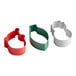 A group of Wilton metal cookie cutters in red, green, and white in the shape of holiday items.