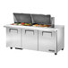 A True stainless steel refrigerated sandwich prep table with food on top.