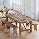 A Lancaster Table & Seating Vineyard Series outdoor table with benches on a wooden floor.