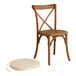 A Lancaster Table & Seating wooden outdoor cross back chair with a round tan cushion.