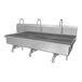 A large stainless steel Sani-Lav wall-mounted multi-station sink with 3 knee-operated faucets.