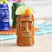 A close-up of a tiki mug with a lime wedge on the rim.
