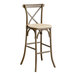 A Lancaster Table & Seating Vineyard Series outdoor bar stool with a tan cushion on the seat.