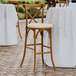 A Lancaster Table & Seating outdoor bar stool with a white cushion on the seat.