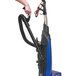 A person using a Powr-Flite Borelli Dual Pro bagged upright vacuum with a black handle.