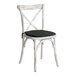 A white Lancaster Table & Seating outdoor cross back chair with a black cushion.