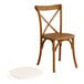 A Lancaster Table & Seating wooden outdoor cross back chair with a white seat pad.