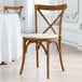 A Lancaster Table & Seating Vineyard Series outdoor wooden chair with a white cushion.