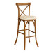 A Lancaster Table & Seating outdoor wooden bar stool with a tan cushion.