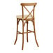 A Lancaster Table & Seating Vineyard Series outdoor bar stool with a tan cushion on a wood frame.