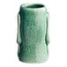 A close-up of a green Acopa ceramic Tiki mug with a handle.