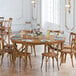 A Lancaster Table & Seating Vineyard Series wooden table and chair set for a dinner party.