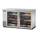 A True stainless steel back bar refrigerator with swing glass doors filled with bottles of beer.