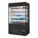 A True refrigerated air curtain merchandiser with glass sides filled with food and drinks.