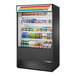 A True refrigerated air curtain merchandiser with food on shelves.