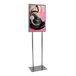 A woman with headphones on using a Chrome Bulletin Sign Holder.