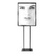 A black rectangular sign holder with a white background holding a black and white picture of a woman's face.