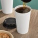 A cup of coffee being poured into a white Choice paper hot cup.