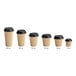 A row of Choice double wall ripple Kraft paper hot cups with black lids.