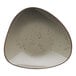 A triangle shaped stoneware bowl with green smoke specks.