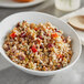 A white bowl of Don's Cranberry Grain Salad on a table.