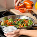 A person sprinkling Regal extra coarse kosher salt on a pan of vegetables.