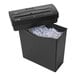 A black Royal CX8 paper shredder with shredded paper and a button.