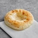 A Just Bagels frozen bialy on a white paper.