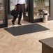 A man walking on a black Lavex Parquet entrance mat.