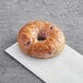 A Just Bagels blueberry bagel on a white paper.