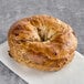 A Just Bagels Cinnamon Raisin Bagel on a white surface.