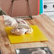 A person cutting a chicken on a Choice multi-colored flexible cutting board.