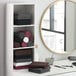 A shelf with Monarch Brands burgundy hand towels in a white room with a mirror.
