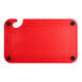 A red plastic Choice cutting board with black grips and a ruler.