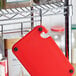 A red Choice cutting board on a wire rack.