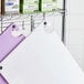 A metal rack with white and purple Choice cutting boards.