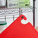 A red Choice cutting board on a metal rack.