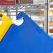 A blue Choice cutting board with grips and rulers on a metal rack.