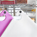 A white Choice cutting board on a metal rack.